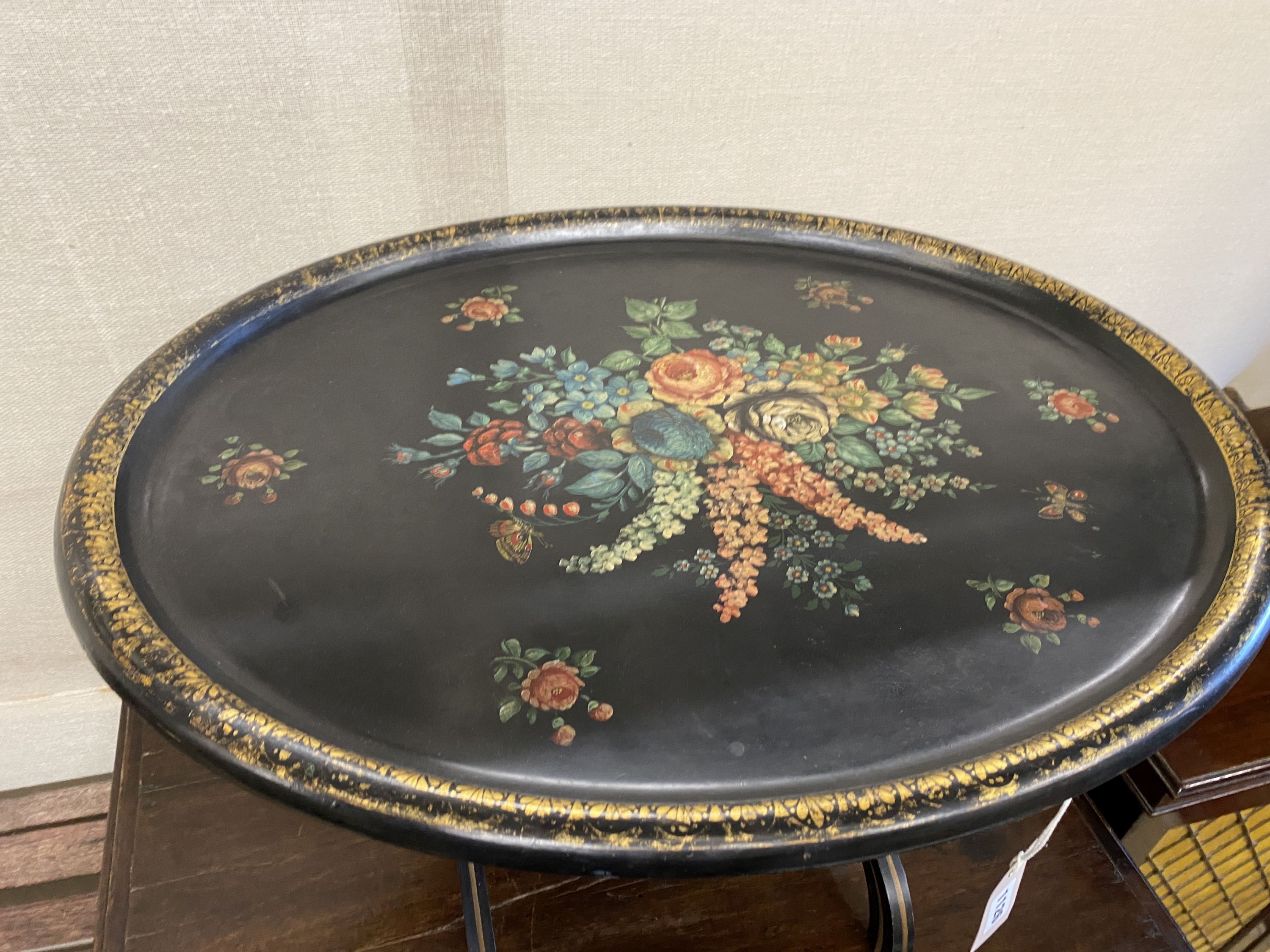 An oval papier mache folding occasional table, width 75cm, depth 60cm, height 52cm